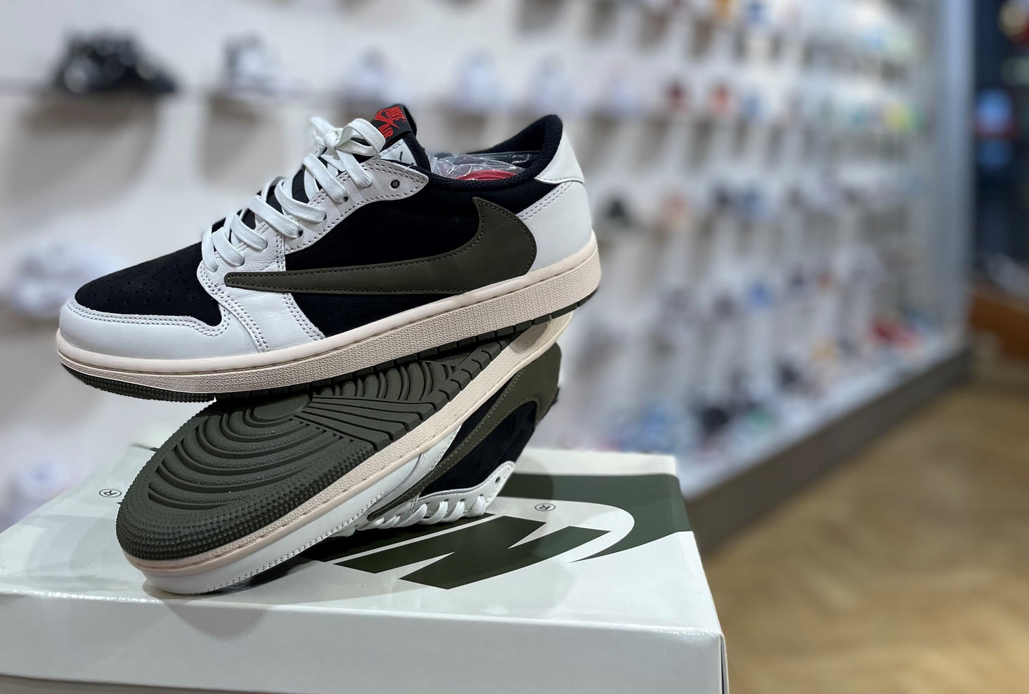 Der Jordan von travis scott in lowtop mit der farbe medium olive grün steht auf dem karton von jordan im alten store in bern